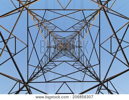Dramatic angle perspective looking up at an electricity pylon from directly below in a horizontal format