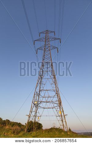 Single electricity pylon with a blue sky background in a vertical format