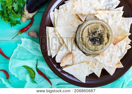 Light dietary pate from eggplant. Baba ganush is an Asian dish. Serve with thin lavash on a ceramic bowl. Top view.