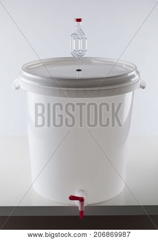 Home beer brewing fermentation bucket with airlock