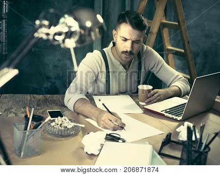 The Handsome Elegant Man Sitting At Home Table, Working And Usin