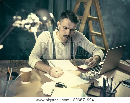 The Handsome Elegant Man Sitting At Home Table, Working And Usin