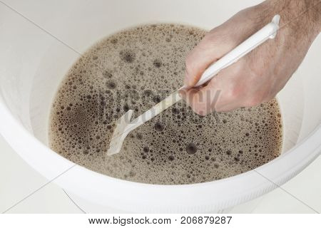 Home craft beer brewing in a plastic container