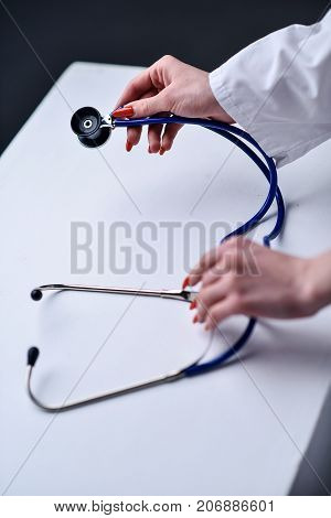 A stethoscope in the hands of the doctor