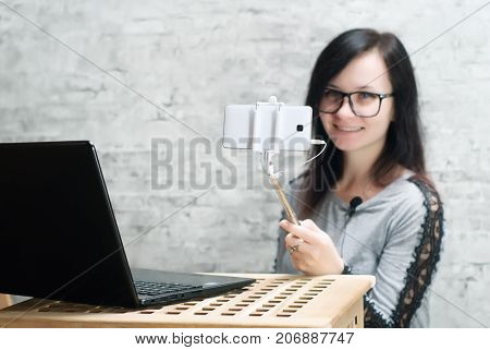 The girl with the glasses is a live broadcast from a mobile phone, Female blogger shoot video using the camera of your smartphone,