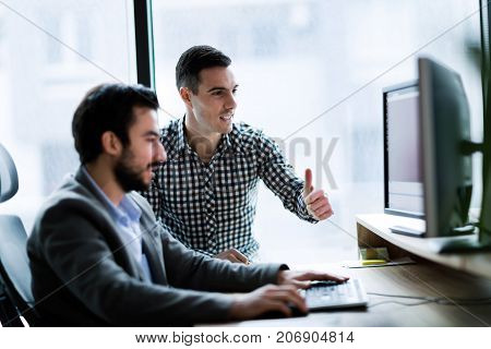 Young businesspeople working on computer in modern office