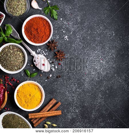 Set of Various spices and herbs on black slate table. Top view with copy space. Foood background. Square.