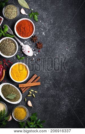 Set of Various spices and herbs on black slate table. Top view with copy space. Foood background. Vertical.