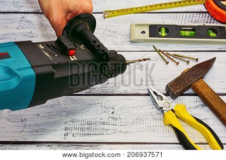Workshop Concept - Hand Tools And A Perforator In Hand