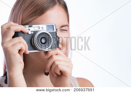 Young pretty girl behind the camera taking photo. Isolated on white