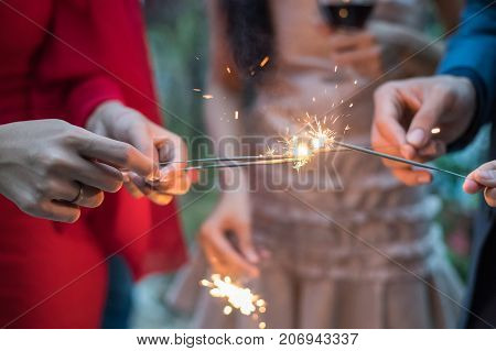 Young People Holding Fireworks At A Party.