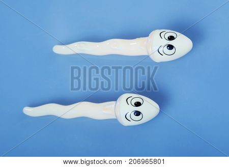 Two sperms (object) compete on blue background