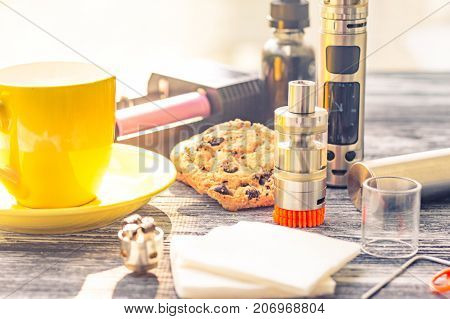 Still Life With Electronic Cigarette With Botle And Coffe On The Wooden Background