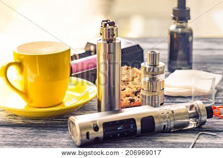 Still Life With Electronic Cigarette With Botle And Coffe On The Wooden Background