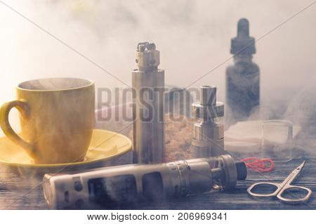 Still Life With Electronic Cigarette With Botle And Coffe On The Wooden Background
