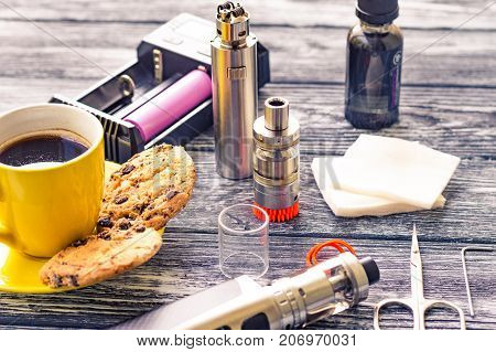 Still Life With Electronic Cigarette With Botle And Coffe On The Wooden Background