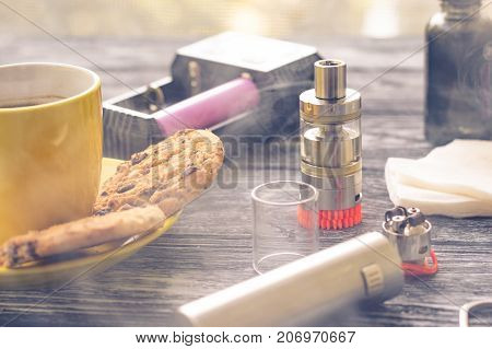 Still Life With Electronic Cigarette With Botle And Coffe On The Wooden Background