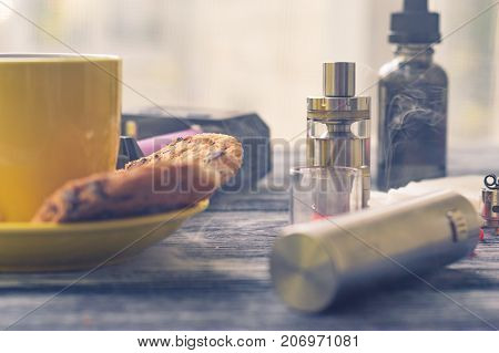 Still Life With Electronic Cigarette With Botle And Coffe On The Wooden Background
