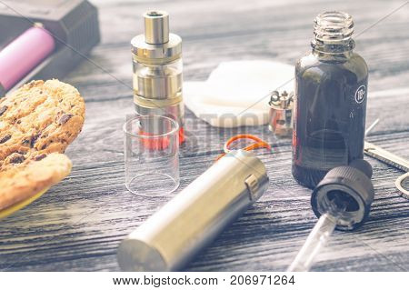 Still Life With Electronic Cigarette With Botle And Coffe On The Wooden Background