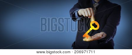 Unrecognizable businessman in blue is pointing at a virtual key that he is holding in his open palm. Business concept for turnkey solution leadership knowledge consulting and customer services.