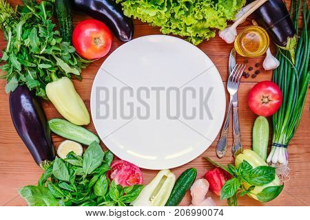 Top view Fresh organic vegetables - ingredients for salad and white empty plate .Diet, detox, vegetarian lifestyle concept . Selective focus.Space foc text