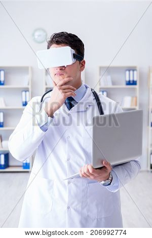Young doctor with vr virtual reality headset working in the offi