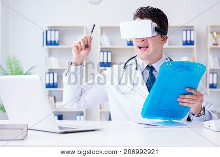 Young doctor with vr virtual reality headset working in the offi