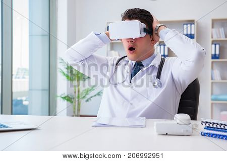 Young doctor with vr virtual reality headset working in the offi
