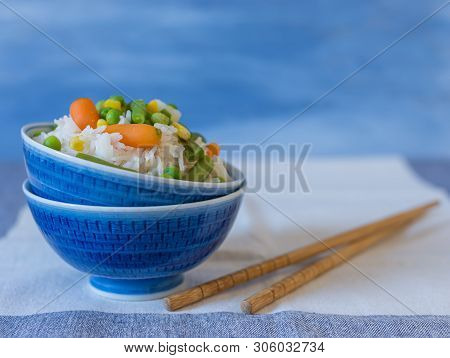 Basmati Rice With Vegetables With Chopsticks  Chinese Concept On Blue Freshie Background