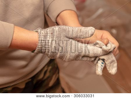 Worker Takes Off Gloves From Hands At A Construction Site.
