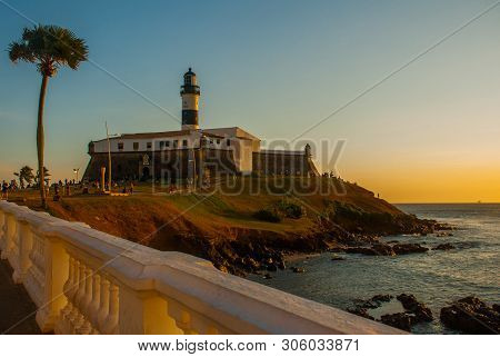 Salvador, Brazil: Sunset. Colorful Sign Stands In Front Of The Colonial Farol Da Barra Lighthouse, T