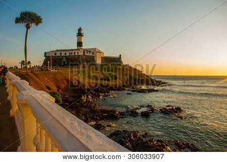 Salvador, Brazil: Sunset. Colorful Sign Stands In Front Of The Colonial Farol Da Barra Lighthouse, T