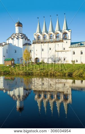The Bell Tower Of The Old Tikhvinsky Uspensky Monastery With A Reflection In The Pond On An October 