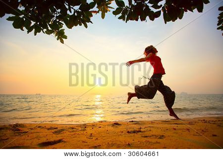Jonge vrouw met op een strand bij zonsondergang