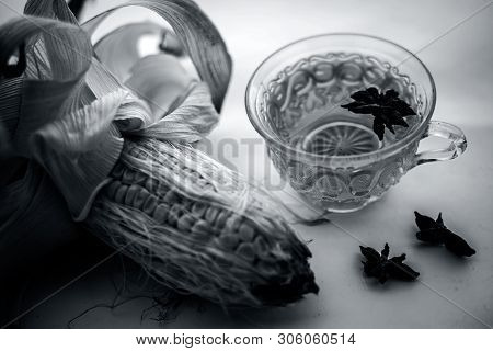 Beneficial Detoxifying Corn Tea In A Glass Cup Isolated On White Along With Some Star Anise Spice.ra