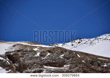 View Of The Snowy Rocky Ridge And Blue Sky At The Foot Of Mount Elbrus In The Azau Valley In The Mou