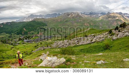 An Hiker Woman Is Looking At View Of Formigal - Spain. Formigal Town In Northern Spain