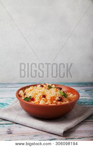 Salad Of Fermented Cabbage And Cranberries With Herbs Stands On A Wooden Blue Table On A Linen Napki