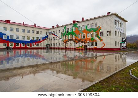 Esso, Kamchatka Peninsula, Russia- 02 October 2014: School Building Exterior With Playground On A We