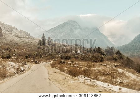 A Long Straight Road Leading Towards A Snow Capped Mountain In Winter Kashmir India
