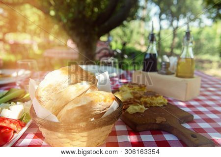 Table Is Set And Waiting For Dining In The Countryside. Red Squared Table Sheets, Albanian Tradition