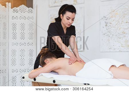 Relaxing Young Woman During Masssage On The Back In The Spa Salon.