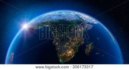 Planet Earth At Night With The Rising Sun With The Light Of Cities Illuminating A Detailed Exaggerat
