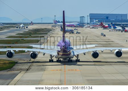 Passenger Airplanes Taxiing On Runway