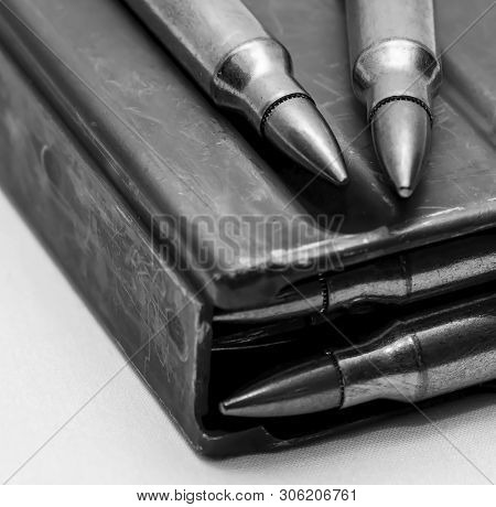223 Caliber Bullets Loaded Into A Rifle Magazine With Two Additional Bullets Shot In Black And White