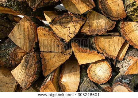 The Wall Is Laid Out With The Ax By The Ax Wood In The Village, The Texture Of Wooden Firewood.