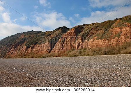 The Sandstone Cliffs Of The Jurassic Era Rising From Salcombe Regis Beach