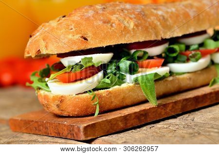 Baguette Sandwich With Egg, Arugula Salad, Tomatoes And Radish