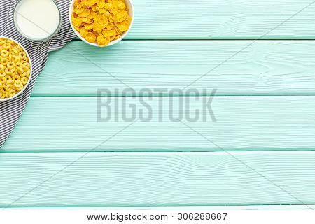 Cereals, Oatflakes And Cornflakes With Milk For Healthy Breakfast On Mint Wooden Background Top View