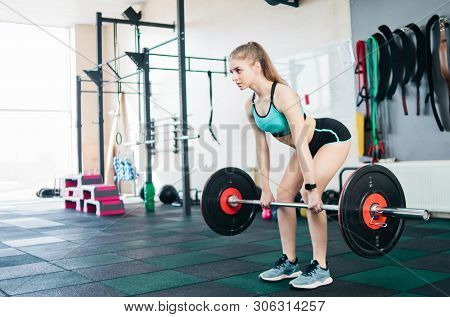 Strong Young Fit Woman Doing Deadlift With A Barbell In The Gym. Free Weight Training